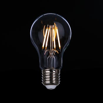 A detailed image of an illuminated LED light bulb against a dark backdrop, emphasizing energy efficiency.